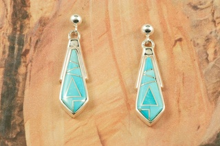 Genuine Sleeping Beauty Turquoise inlaid between ribbons of Sterling Silver. Beautiful Sterling Silver Post Earrings feature precision channel inlay. Designed by Navajo Artist Calvin Begay. Signed by the artist.